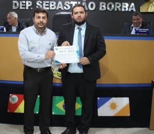 O presidente da Cmara Nbio Gomes, entrega a comenda que registra Moo de Aplausos para o gerente do BASA Miracema, Everton Alves Ferreira